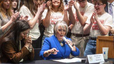 New Mexico governor signs bill that bans some guns at polls and extends waiting period to 7 days